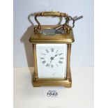 A Brass Carriage clock with Roman numerals and bevelled glass,