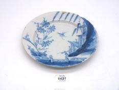 An 18th century English Delft plate well painted with flowers and a pagoda to the side,