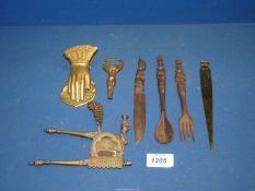 A carved wood knife, fork and spoon, brass bottle opener, nutcracker, paper knife, etc.