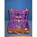 A brown leather Gent's vanity case with purple lining, fitted with silver topped bottles, maker L.T.