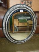 An oval Mirror with moulded decoration, some wear. 23" x 20".