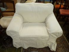 A cream upholstered Fireside Chair having corded off white loose fabric covers.