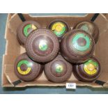 Two sets of Lawn Bowls, both brown, one with interlinked circle detail by Cotswold 'Goldline',