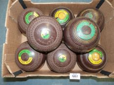 Two sets of Lawn Bowls, both brown, one with interlinked circle detail by Cotswold 'Goldline',