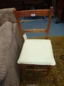 A cane seated Bedroom Chair having a pale green gingham upholstered cushion.
