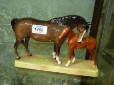 A Beswick bay mare and chestnut foal on china plinth.