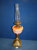 A brass, square based oil Lamp with decorative pink glass reservoir, with chimney, 26 1/2'' tall.