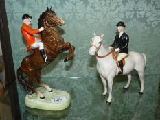 Two Beswick ornaments of horses including one rearing with rider in red jacket and palomino with