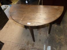 An early 19th century Oak demi-lune side table standing on chamfered tapering legs,