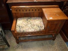 A Priory Oak/old charm type telephone seat having a recessed panelled doored cupboard to the side