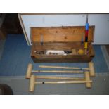 A Croquet set including four mallets and four balls, five hoops and post, in a wooden carrying case.