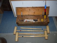 A Croquet set including four mallets and four balls, five hoops and post, in a wooden carrying case.