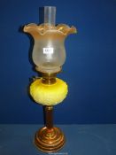 An oil lamp with a yellow glass reservoir, etched glass shade and clear chimney. 26" tall.
