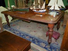 A pull-out extending Satinwood Dining Table standing on turned,