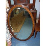 A Mahogany framed oval mirror. 39" high x 25" wide.