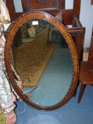 A Mahogany framed oval mirror. 39" high x 25" wide.