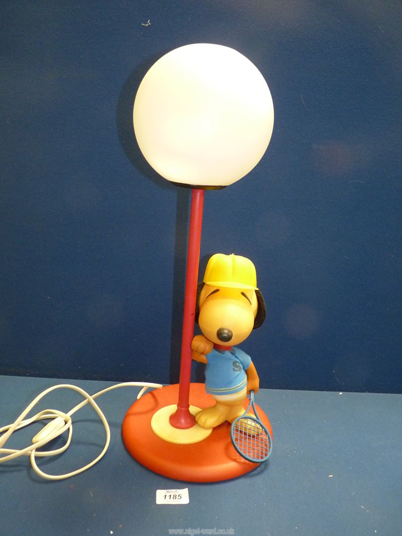A circa 1960's 'Snoopy' table lamp in tennis kit (marks and wear to clothes), with globe shade,