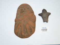 A flat piece of terracotta in the form of a seated person clasping their hands,