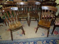 A set of four arts and crafts dark Beechwood Kitchen Chairs having solid seats,