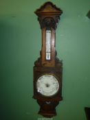 A large vintage mercury Aneroid barometer having carved decoration. Some splits to wood. 41" tall.
