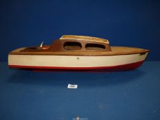 A wooden model of a vintage motorboat "Maggie" with a propeller,