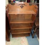 A mid Oak Arts & Crafts floor standing bookshelves having fretworked side and back details to the