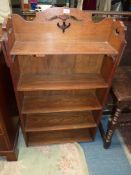 A mid Oak Arts & Crafts floor standing bookshelves having fretworked side and back details to the