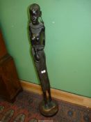 A large ebonised carving of a Tribal woman, 42" tall.