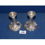 A pair of Silver candlesticks decorated with scrolls, foliage and a bird, Birmingham 1979,