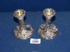 A pair of Silver candlesticks decorated with scrolls, foliage and a bird, Birmingham 1979,