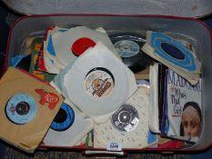 A red suitcase containing 45 RPM records to include; Madonna, Spring Water, David Edmunds, etc.