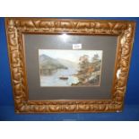 A framed and mounted Watercolour depicting a river landscape with figure in a rowing boat and