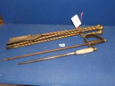 Two fire pokers one in the shape of a sword and a brass companion set having spiral twist handles.