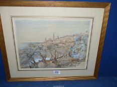 A framed and mounted Watercolour depicting a Mediterranean town on a hillside, no visible signature,