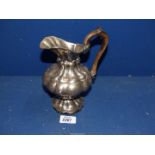 A continental white metal Jug with lobed body, wooden handle, impressed mark to base.