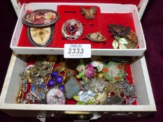 A quantity of costume jewellery brooches including china, copper leaf,