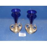 A pair of Art Nouveau silver bud vases with exaggerated handles and Bristol Blue trumpet shaped