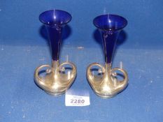 A pair of Art Nouveau silver bud vases with exaggerated handles and Bristol Blue trumpet shaped