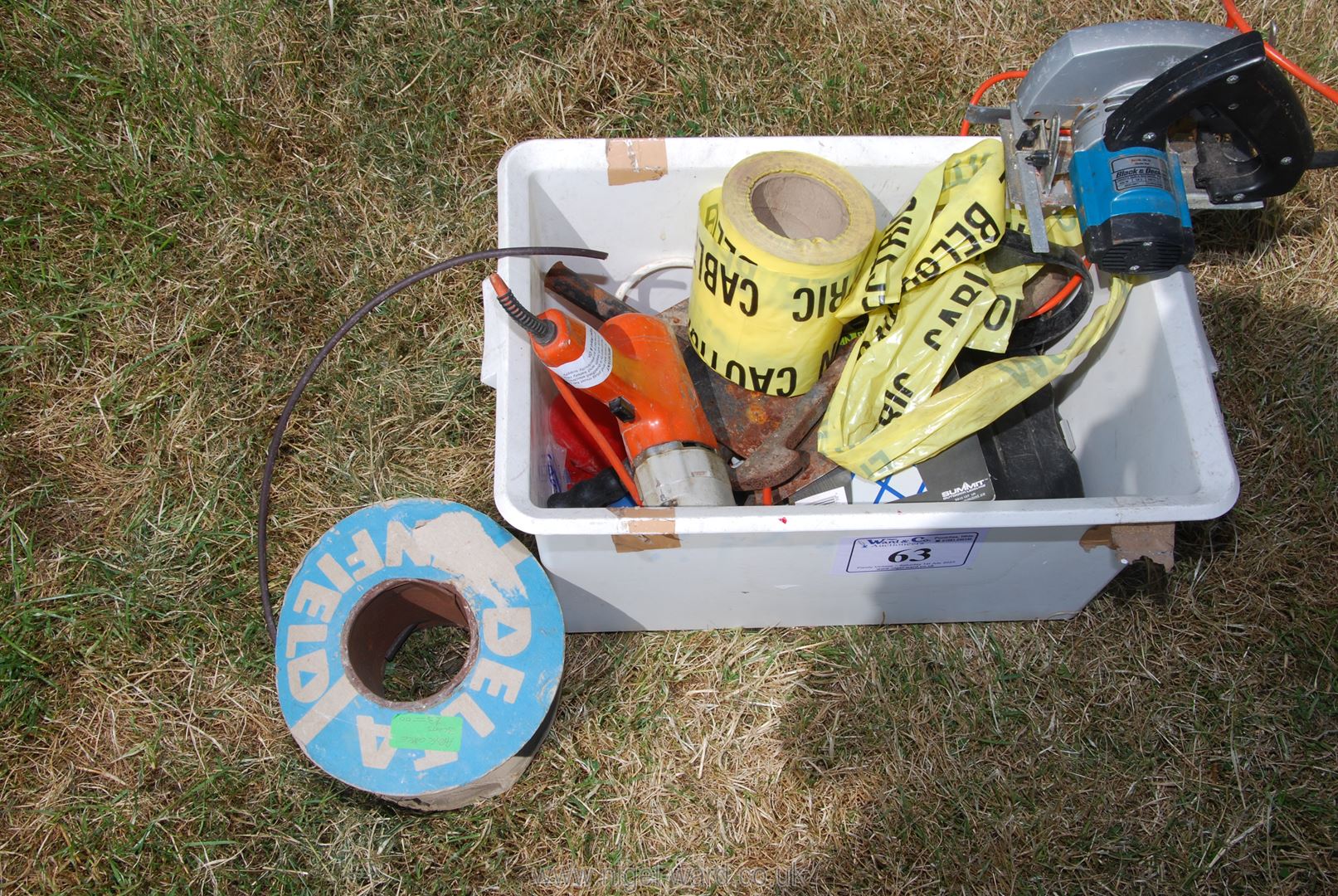 A box containing electric cable, trowels, Black and Decker jigsaw, extension lead, etc.