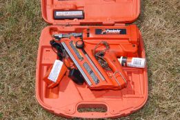 Paslode" cordless nail gun with charger and battery.