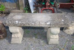 A concrete garden seat on plinths, 33'' x 14'' x 17'' high.