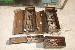 Four military cases of brass taps, pipe fixings, old spanners etc.