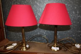 A pair of B&Q brass table lamps with red shades, 17" tall.