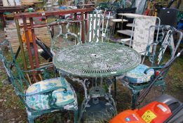 A circular Aluminium table, 31 1/2'' diameter with four matching chairs,