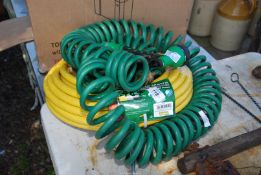 A new roll of yellow hose pipe, green Susi hose pipe and a water sprayer attachment.