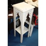 A wooden white painted two tier plant stand.