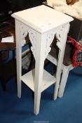 A wooden white painted two tier plant stand.