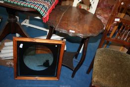 A scalloped edge occasional table with lower shelf and a picture mirror.