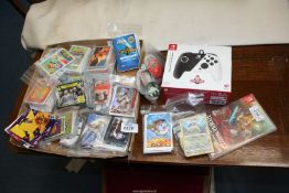 A Nintendo Switch controller, one game and quantity of trading cards.