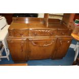 A dark wood 40's/50's style buffet sideboard with cutlery drawer over three cupboard doors,